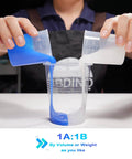 Pouring sapphire blue and white liquid silicone mold making kit into a clear container, 1:1 by volume ratio, DIY project.