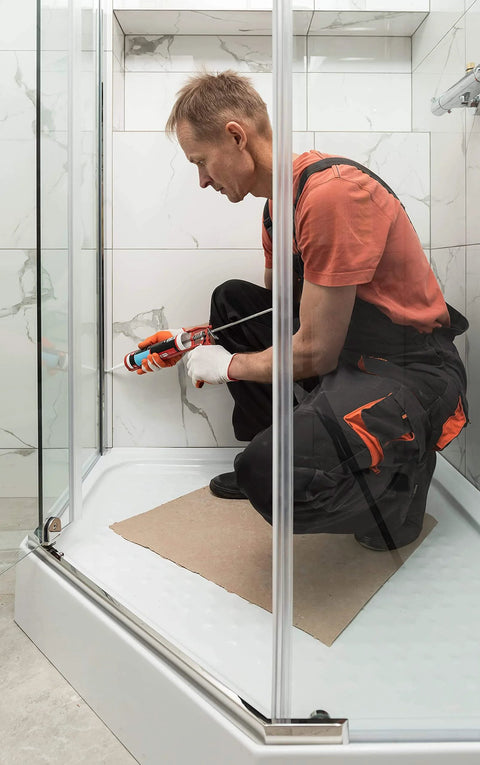 Person applying Translucent RTV Silicone Sealant Caulk For General Purpose Use Waterproof Odor Free No Smell in a shower stall