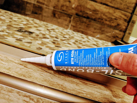 Applying Heavy Duty Food Safe Silicone Sealant RTV 4500 Clear Two Pack 2.8 Fluid Ounce Each to a countertop edge for sealing.