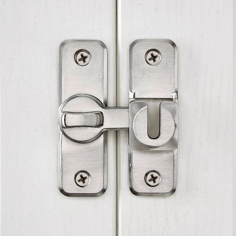 Installed Silvery Enhanced Security Flip Latch Lock on a white door with visible screws and shiny finish, suitable for barns and gates.