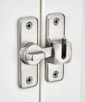 Silvery Enhanced Security Flip Latch Lock installed on a white door, showing heavy-duty design and versatile angle adjustment for barns and gates.