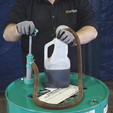 Person using Ironton Siphon Drum Pump - 7 GPM on a 55-gallon drum with hose filling a container.