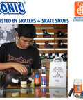 Person using Complete Pro Grade Skate Bearing Cleaning Kit with 8 oz Citrus Cleaner in skate shop with inline skates.