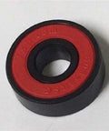 Close-up of an 8-Pack Skateboard Black Bearings - Nylon Cage & Red Rubber Seals 8x22x7mm bearing with red seal.