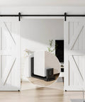 Sliding barn door bottom floor guide with adjustable U shape, black finish, installed on floor with white barn doors, close-up view inset.