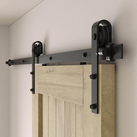 Close-up of 6.6FT sliding barn door hardware kit for single door, carbon steel black track system installed on wooden door