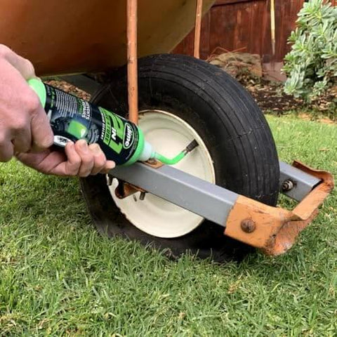 Applying Slime 10193 Tire and Tube Sealant Puncture Repair Sealant, 2-in-1, on a wheelbarrow tire outdoors