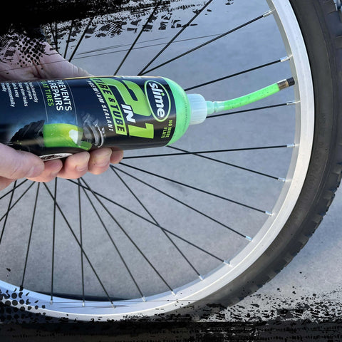 Applying Slime 10193 Tire and Tube Sealant Puncture Repair Sealant to a bicycle tire, 2-in-1, 16oz bottle, eco-friendly product