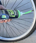 Slime 10193 Tire and Tube Sealant Puncture Repair Sealant, 2-in-1, 16oz bottle being applied to a bicycle tire