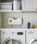 Smart Laundry System With O3 Water Technology Delivers Detergent Free Cleaning For Every Load By Transforming Tap Water Into Ozone Rich Cleaning Water Suitable For Standard Washers And Under Counter Installation installed above washing machines in a laundry room scene.