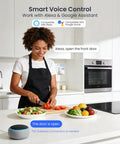 Woman in kitchen using smart voice control with Alexa device, preparing vegetables on counter.