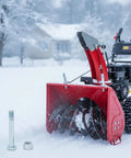 1/2-13 Nuts Bolts Assortment With 3/4 Inch Head and locking nylon nut beside red snow blower in snowy outdoor scene