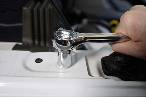Person using ratchet from 121 Piece Mechanic Tool Set With One Quarter And Three Eighth Inch Drive Sockets for auto repair