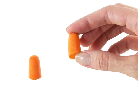 Hand holding a soft foam earplug from Disposable Ear Plugs Pack Of 200 Pairs With 32 dB Noise Reduction Soft Foam Comfort Hearing Protection.