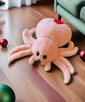 Super Soft Pink Spider Plush Toy For Kids And Adults Huggable Stuffed Animal 9.8 Inch Plush Pillow on wooden floor