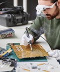 Technician soldering a motherboard using Brass M3 Hex Standoffs 12 Pack For Motherboard With 6mm Male To Female Studs And Copper Spacers Pillars 14mm Total Length Includes M3 X 6mm Screws Durable Copper Construction For Solid PC Build.