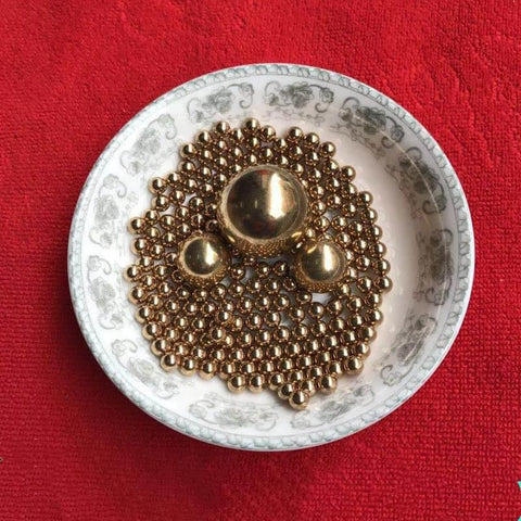 4.76mm 200pcs Solid Pure Copper Balls - Brass Ball Bead displayed in a decorative bowl on a red background