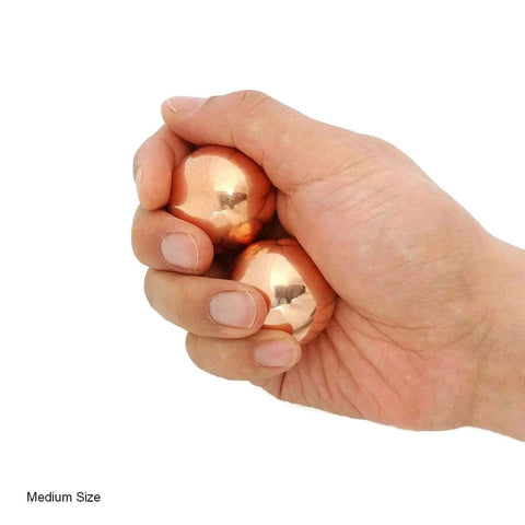 Hand holding 1.5 Inch Solid Copper Baoding Balls with Carry Pouch for Hand Therapy, Exercise, and Stress Relief