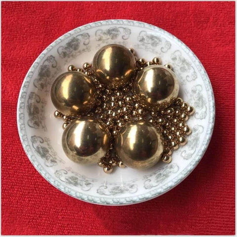 4.76mm 200pcs Solid Pure Copper Balls - Brass Ball Bead in decorative dish, showcasing high-polish finish and intricate design.