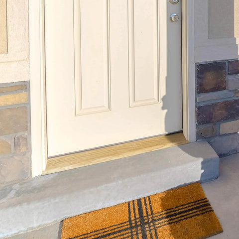 Solid Red Oak Interior Threshold installed at doorway, showing durable wood transition with doormat, enhancing entry look. Size: 36 x 3 x 1 inches.