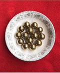 2.381mm 500pcs Solid Pure Copper Balls - Brass Ball Bead displayed on a decorative plate