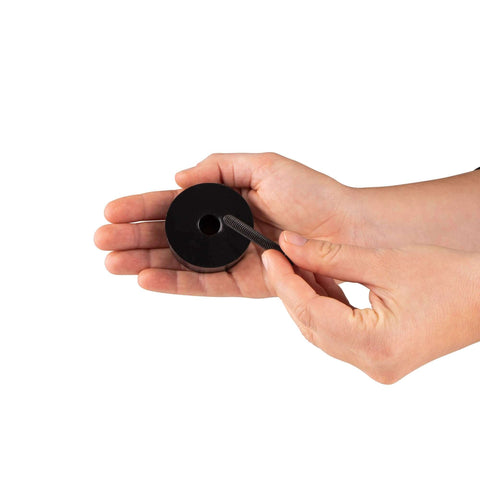 Hands holding a Sorbothane anti-vibration leveling mount with 1/4-20 threads, 2 inch stud, 2 inch diameter, 70 Duro, 2 pieces.