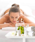 A woman receiving a spa massage with essential oils and towels on a tray; relaxation and rejuvenation scene.
