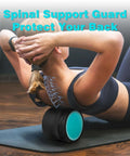 Person using a black and teal back roller wheel for deep tissue massage and back stretching, promoting spinal support.