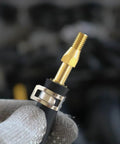 Close-up of a spring band type hose clamp with 12mm inner diameter on a hose, highlighting zinc plated steel and brass fitting.