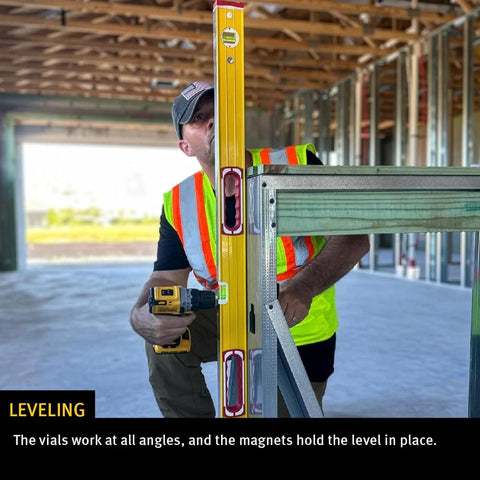Worker using the Stabila Type 96M Magnetic Level offers 96 inches of professional-grade accuracy on metal frame at construction site.