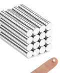 Stacks of 240 Pack 5x2mm Neodymium Magnets For Crafts Whiteboards And Kitchen Cabinets Durable Rare Earth Magnets next to fingertip.