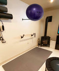 Wall Mounted Stainless Steel Exercise Ball Holder for 13 to 34 Inch Balls in home gym with yoga and stability accessories