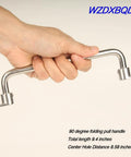 304 Stainless Steel Folding Pull Handle 90 Degree Folding Door Pull Cabinet Drawer Furniture Handle Heavy Duty 9.4 Inch Total Length 238 Mm Center Hole Distance 218 Mm Ideal For Cabinets Chests Tool Boxes And Furniture Easy Mounting held in a hand, demonstrating its foldable design.