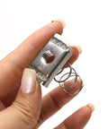 Hand holding stainless steel 3/8-16 standard strut channel nut with thickened spring for mounting and connecting slotted strut systems.