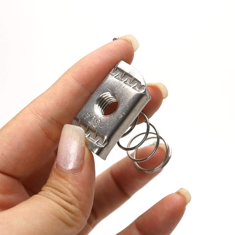 Hand holding stainless steel 3/8-16 standard strut channel nut with thickened spring for mounting and connecting slotted strut systems.