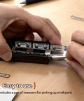 Hands using tweezers to handle stainless steel bearing ball set for precision machinery repairs