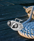 Angled front view of mirror-polished stainless steel cam cleat with rope on a wooden deck