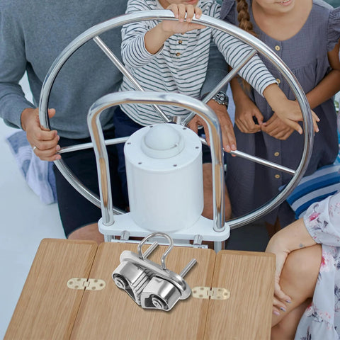 Front view of Beavorty stainless steel cam cleat with swivel hinge and leading ring on a wooden cockpit table