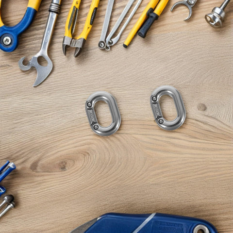 Stainless steel 8mm quick link chain connectors, two pieces, on a wooden work surface