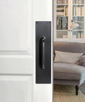 Two Piece 16 Inch Stainless Steel Door Handle Pull And Push Plate Set installed on a white door near a cozy room, brushed black finish
