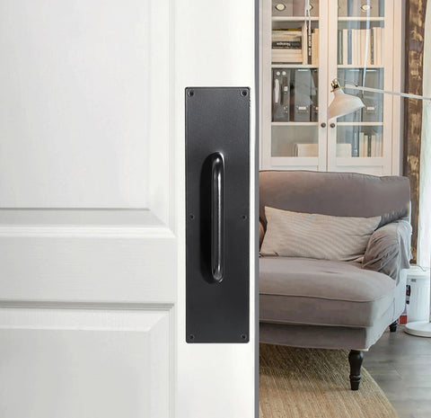 Two Piece 16 Inch Stainless Steel Door Handle Pull And Push Plate Set installed on a white door near a cozy room, brushed black finish