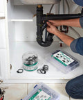 Man installing 175 Pcs Stainless Steel Hose Clamp Kit With Eight Sizes From One Quarter Inch To Two Inches under sink
