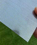 Close-up of stainless steel perforated sheet 16x10 in, 304 grade, 19 gauge with 1/16 inch openings, held by a hand