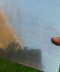 Close-up of a Stainless Steel Perforated Sheet 16x10 In, 304 Grade, 19 Gauge With 1/16 Inch Openings, held outdoors.