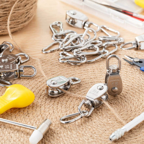 30 Pcs Single Pulley Block System 304 Stainless Steel Pulley Wheel Hanging Wire Towing Wheel with 30 Pcs Spring Snap Hook, Lifting Wire Rope Single Swivel Roller, Silver(M15) displayed on burlap surface with tools around.