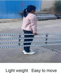 Person carrying Stainless Steel Roller Conveyor Belt For Light Duty Gravity Conveyor Table with ABS Plastic Rollers outdoors.