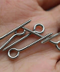 100 Pack Stainless Steel Screws 1 Inch 25mm For Jerk Baits Lure Making And DIY Fishing Lures Hardware Silver Finish For Crankbait And Lure Assembly Durable And Corrosion Resistant For Saltwater Use shown in hand.