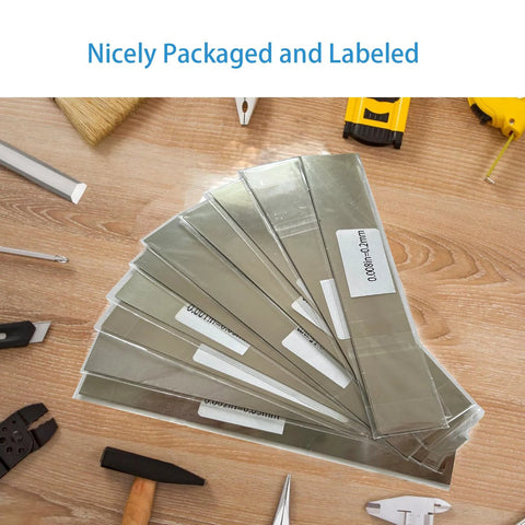 50 Piece Shim Stock Assortment In 304 Stainless Steel Strips 1 Inch Wide By 6 Inch Long Metal Shims For Leveling And Gap Filling In Home Improvement For DIYers And Pros 0.001 Inch To 0.01 Inch Thickness neatly packaged and labeled on a wooden table with tools.