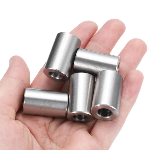 Hand holding four-piece stainless steel spacer set of four five sixteenth inch bore five eighths inch outer diameter one inch length spacers.