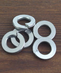 100 Pack Size 10 Stainless Steel Split Lock Washers For Screws And Bolts on wooden surface